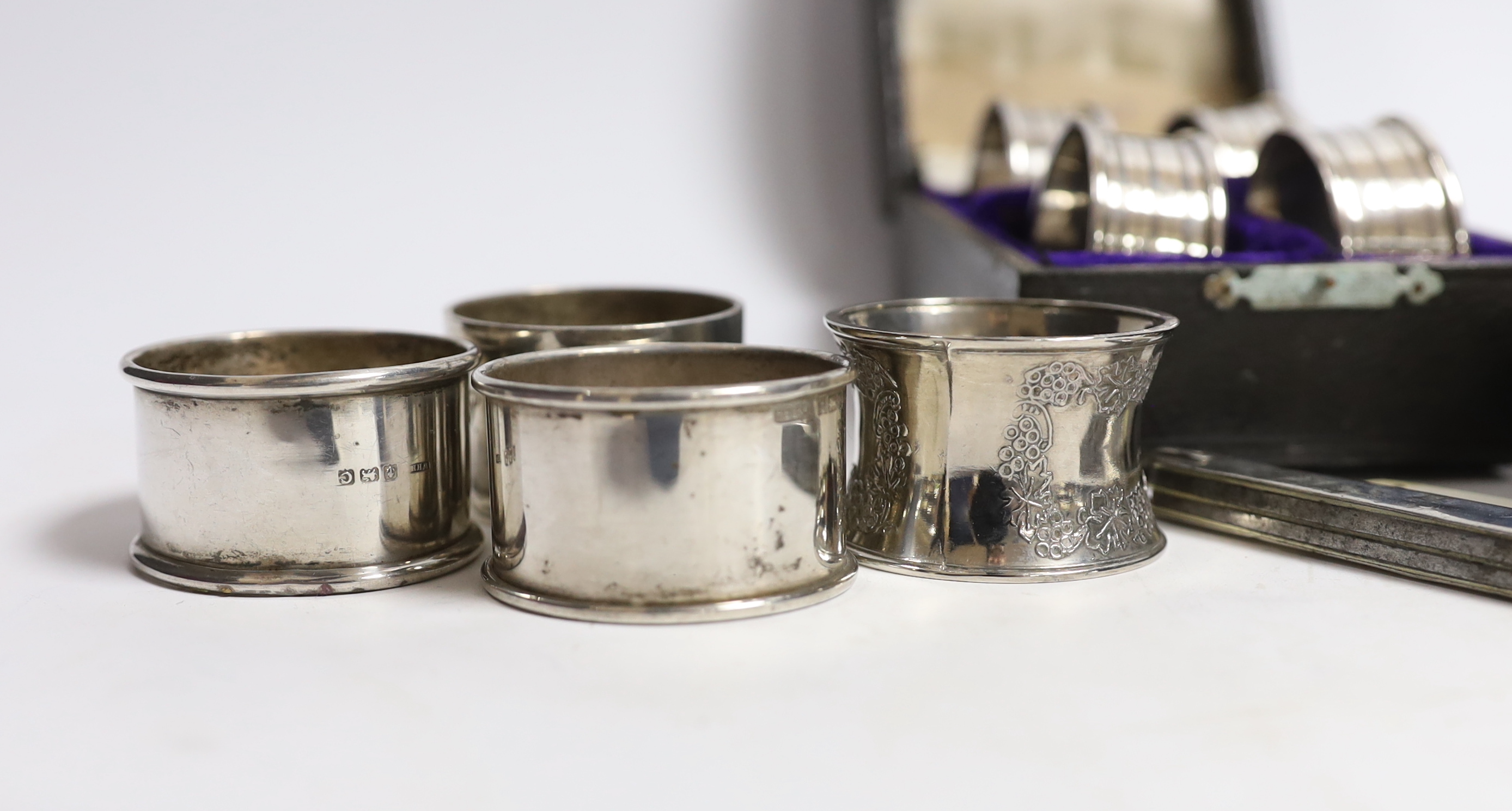 A cased set of four George V silver napkin rings, Rolason Brothers, Birmingham, 1920, together with five other assorted silver napkin rings, three plated napkin rings, two mother of pearl mounted fruit knives and a silve